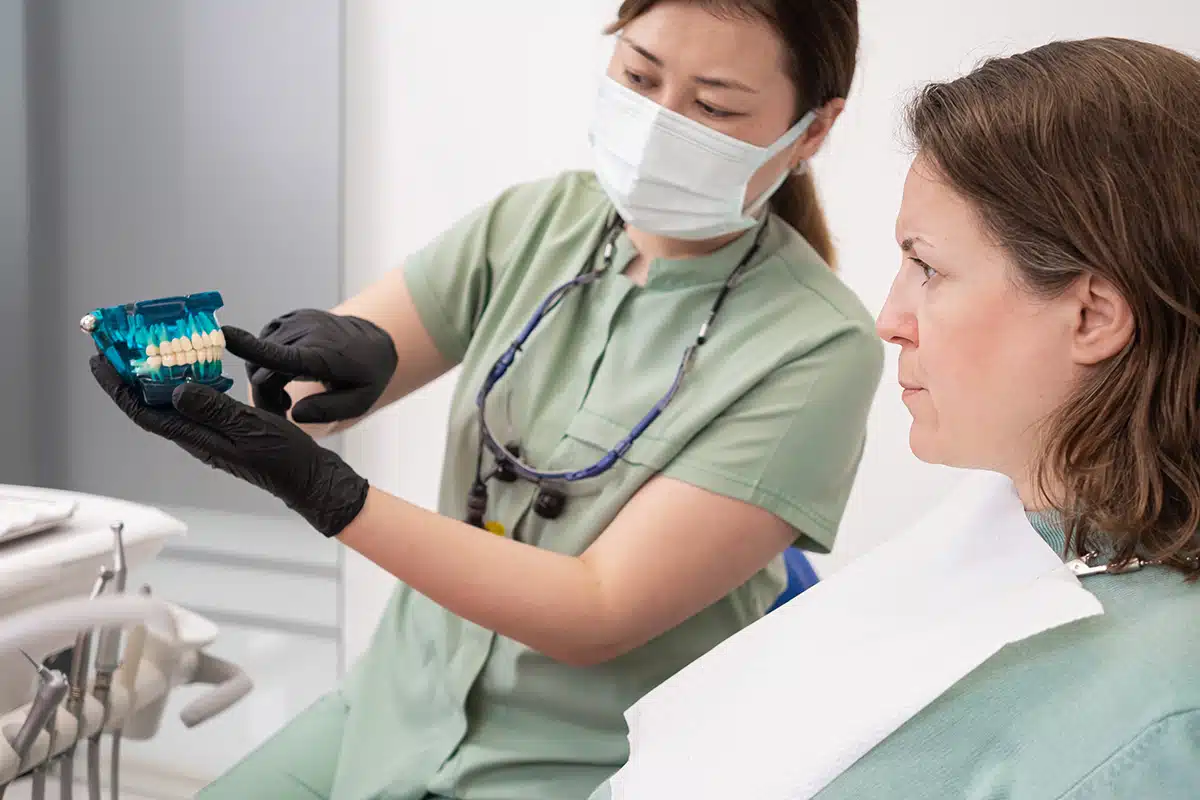dentist woman in protective mask and gloves with patient in dental clinic.